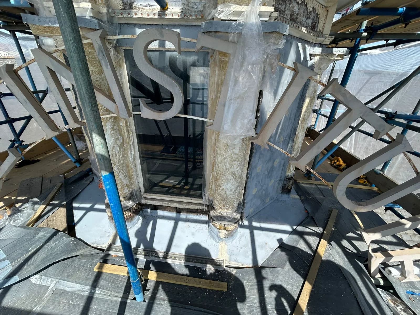 Detached ‘INSTITUTE’ signage letters during restoration of the O2 Institute Birmingham cupola — Grade II listed heritage roofing