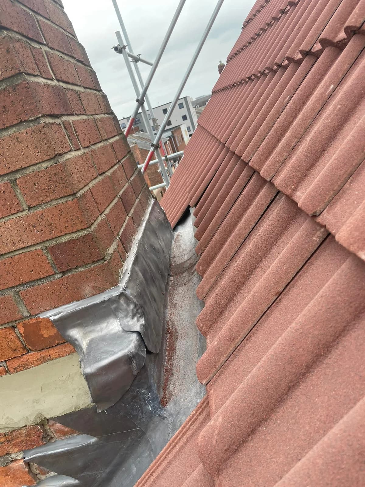 Completed natural slate pitched roof at sunset with chimney and rooflight detail visible — pitched roof replacement County Durham
